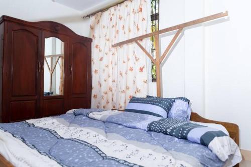 a bed with blue and white sheets in a bedroom at Marangu Serenity Homes in Marangu