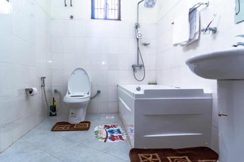 a white bathroom with a toilet and a sink at Marangu Serenity Homes in Marangu