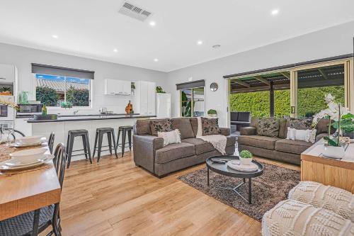a living room with a couch and a table at Kabinga Kottage - Echuca Holiday Homes in Moama