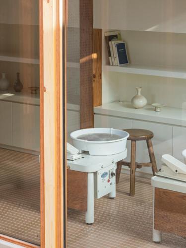 a bathroom with a white sink and a stool at Nostalgia Hanok Hotel in Seoul