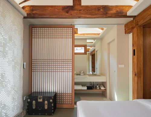 a bedroom with a door leading to a bathroom at Nostalgia Hanok Hotel in Seoul