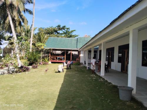 a group of people standing outside of a building at Losmen katiet beach front, lances right surf camp peter Homestay in Katiet