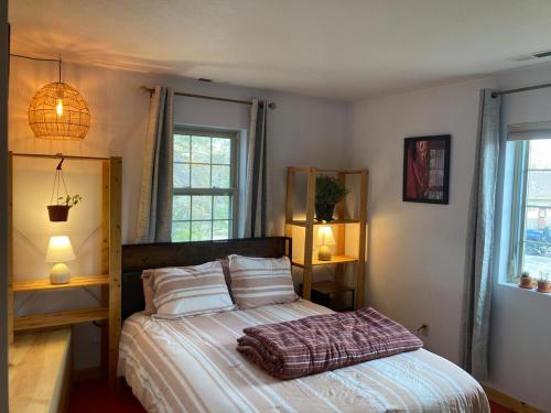 a bedroom with a bed and two windows at InnSpiration Escalante - Premium Vacation Rental 3-5 Beds in Escalante