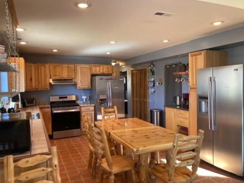 a kitchen with a wooden table and stainless steel appliances at InnSpiration Escalante - Premium Vacation Rental 3-5 Beds in Escalante