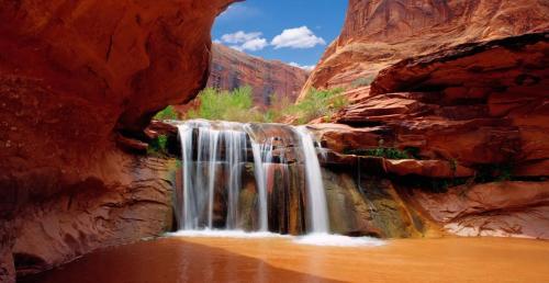 a waterfall in the middle of a canyon at InnSpiration Escalante - Premium Vacation Rental 3-5 Beds in Escalante