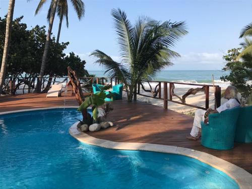 a man sitting in a chair next to a swimming pool at Sublime Eco Hotel - Palomino Tayrona By GHO Hoteles in Palomino