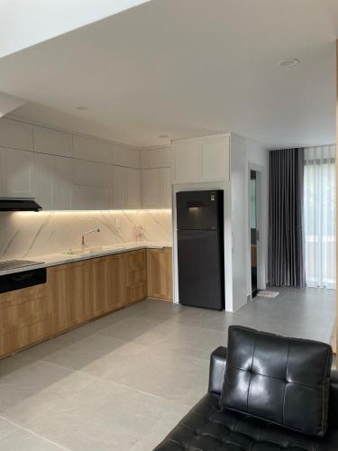 a living room with a couch and a kitchen at Lam & Anna's Home in Bến Lức