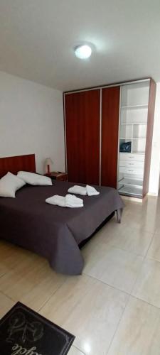 a bedroom with a large bed with towels on it at Las Costas - Tu descanso in Cañuelas