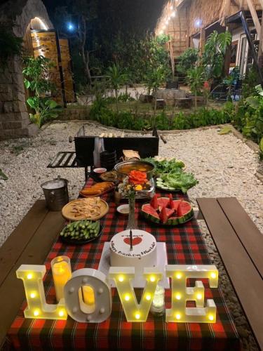 a table with a cake and a sign that says love at Upes Garden Homestay Bien Ho in Bien Ho
