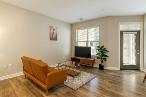 a living room with a couch and a tv at CozySuites - Penrose On Mass with pool and parking#10 in Indianapolis