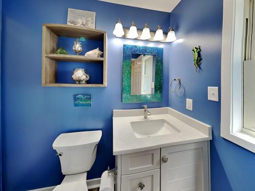 a blue bathroom with a toilet and a sink at Slow Motion #8A in Topsail Beach