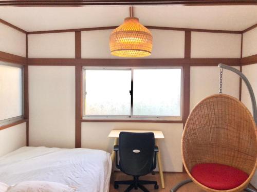 a room with a bed and a desk and a lamp at HOKUSAI-KAN Osaka Taisho in Osaka