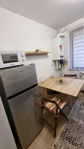a kitchen with a refrigerator and a table with a microwave at Apartament central Suceava in Suceava