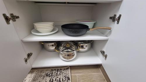 a cupboard with dishes and a bowl on it at Apartament central Suceava in Suceava