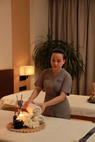 a woman standing in front of a table with candles at The Empyrean Cam Ranh Beach Resort in Cam Ranh