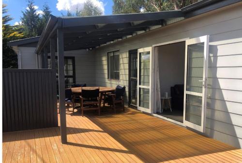 a deck with a table and chairs on a house at Mackenzie Batch in Twizel