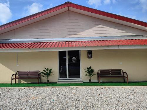 twee banken voor een gebouw bij Reds Roomstay Pantai Penarik 4 in Pulau Che Selamah