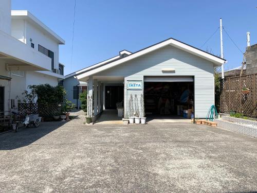 a garage with a door open next to a building at Guesthouse IKETA in Niijimamura