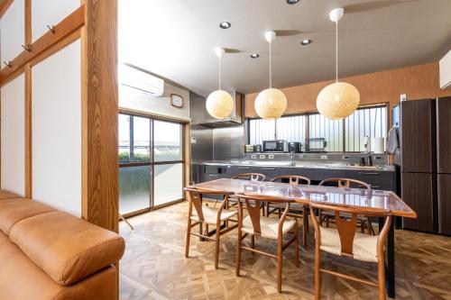 eine Küche und ein Esszimmer mit Tisch und Stühlen in der Unterkunft 一棟貸切の和風プライベートヴィラ プール花火バーベキュー in Fukutsu