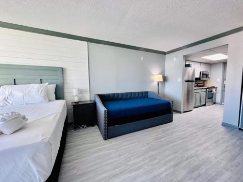 a hotel room with a bed and a blue chair at Lovely Beach View Condo,King,Pool,M11 in Myrtle Beach