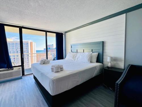 a bedroom with a large bed and a large window at Lovely Beach View Condo,King,Pool,M11 in Myrtle Beach