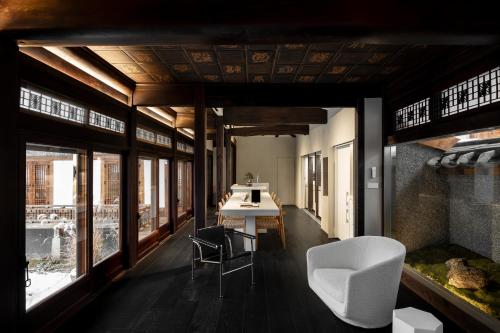 a room with a table and chairs and windows at Nostalgia Hanok Hotel in Seoul