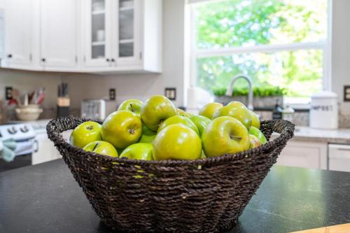 a basket of green apples sitting on a counter in a kitchen at Delightful family-friendly home in the heart of WA in Olympia