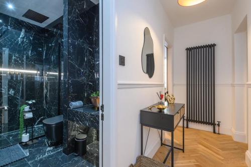 a bathroom with a shower and a vanity and a mirror at Paradise Boutique Deluxe - Leeds City Center - Steps to Ivy Asia in Leeds