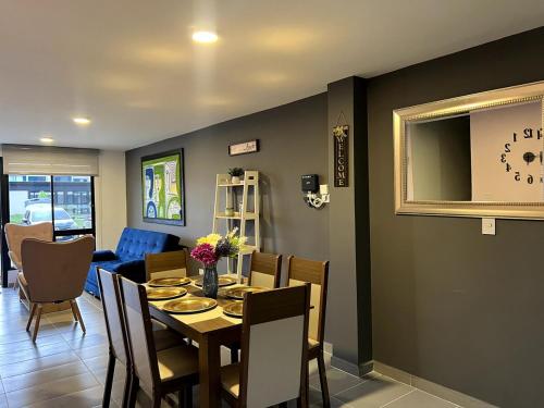 a dining room with a table and a clock on the wall at Hermosa Casa Familiar Quindío - Descanso - Jacuzzi in La Tebaida