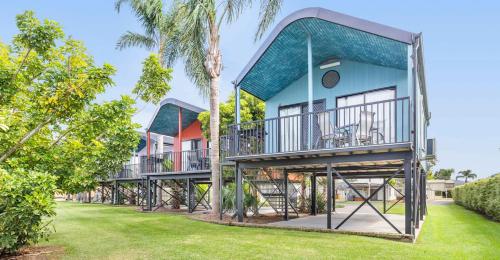 a house with a wrap around porch with trees at Moruya Holiday Park in Moruya