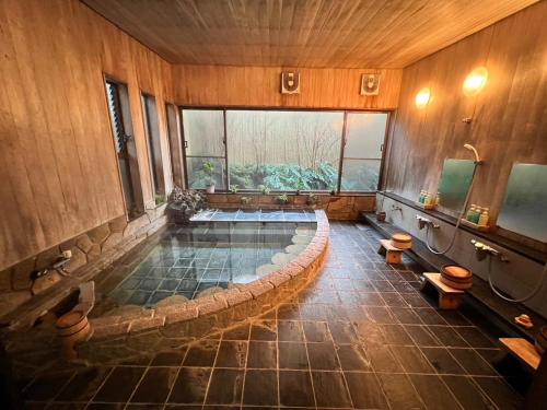 箱根町にあるOnsen & Garden -Asante Inn-の広い客室で、中央にバスタブが付いています。