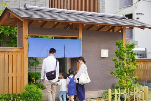 a family standing outside of a house at LAZULI Hiroshima Hotel and Lounge in Hiroshima