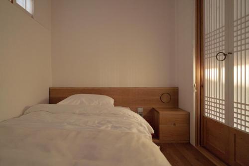 a bedroom with a white bed and a window at Nostalgia Hanok Hotel in Seoul
