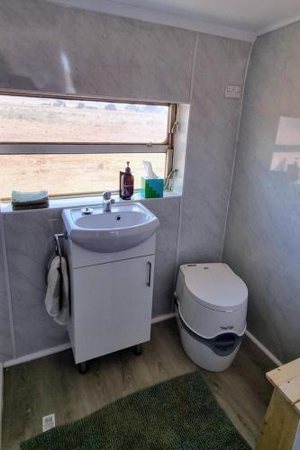 Un baño pequeño con lavabo e inodoro. en Quentin Park Hideaway, en Peterborough