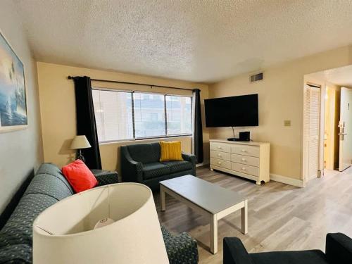 a living room with a couch and a tv at *A FAMILY GETAWAY*Pool*Steps to the Beach*Approved Dogs*D18 in Myrtle Beach
