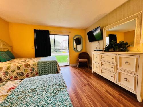 a bedroom with two beds and a dresser with a mirror at *A FAMILY RETREAT*Pool*Steps to the Beach*Approved Dogs*D18-9 in Myrtle Beach