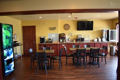 een eetkamer met tafels en stoelen en een keuken bij Heartland Hotel & Suites in Rock Valley