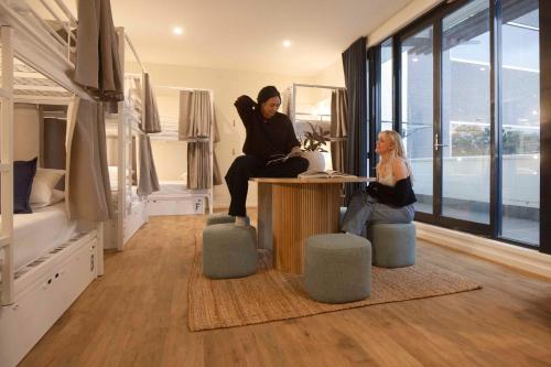 two women sitting at a table in a room at Little Drifter Canberra in Canberra