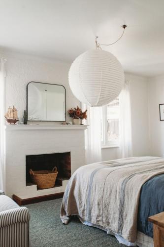 a bedroom with a bed and a mirror and a fireplace at Sunways in Orford