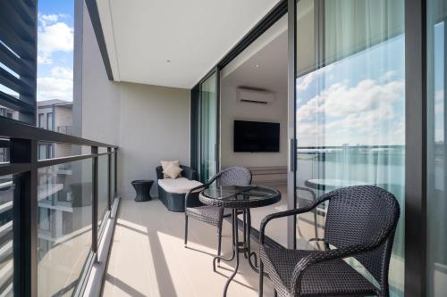 a balcony with chairs and a table on a building at Cassia Residences in Laguna by Banyan Living in Laguna Phuket