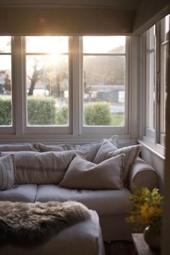 a couch in a living room with two windows at Sunways in Orford