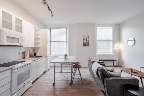 a kitchen and living room with a couch and a table at CozySuites Sky Central #3 in Cincinnati