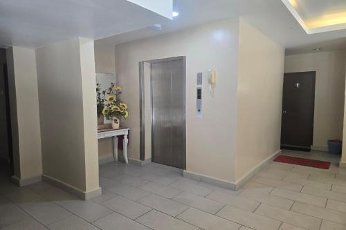 a hallway with a door and a table with flowers at Fast Hotel Melaka Near Menara Taming Sari - 2 Mins Only in Melaka