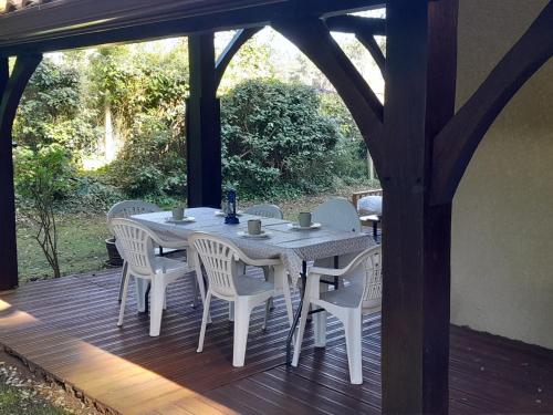 une table et des chaises sur une terrasse en bois dans l'établissement Maison familiale avec jardin, près de l'océan dans un quartier calme - FR-1-239-820, à Labenne