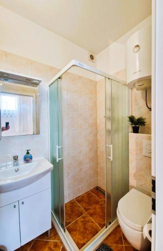a bathroom with a shower and a toilet and a sink at Comfortable Rooms - City Place in Split