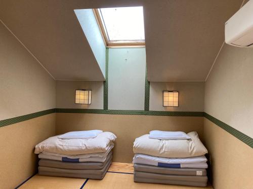 中富良野町にあるペンション ラクレットの窓のある小さな部屋にベッドが2つある