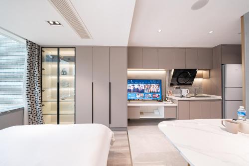 a room with a kitchen with a bed and a television at Today Aparthotel West Lujiazui Shanghai in Shanghai