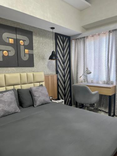 a bedroom with a bed and a desk and a chair at Be Residences in Cebu City