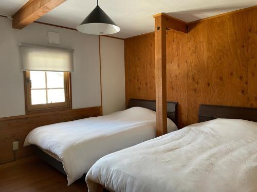 上山市A private inn where you can relax in nature and enjoy with groups of up to 14 people的有两张床和一扇窗户的卧室