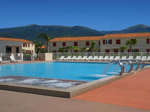 - une grande piscine avec des chaises longues et un billard dans l'établissement Appartement F2 avec terrasse, jardin, parking et accès piscine à 500m du village d'Argelès-sur-Mer - FR-1-732-63, à Argelès-sur-Mer